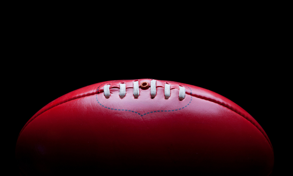 Grief in community_web banner A red Australian Rules football.